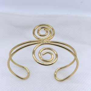Lemme Buy Twirl Cuff, a polished gold spiral arm cuff for women, shown on a white textured background.